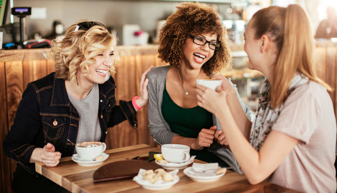 Women laughing at a coffee shop